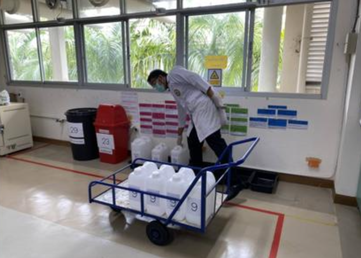 Staff transporting hazardous waste containers