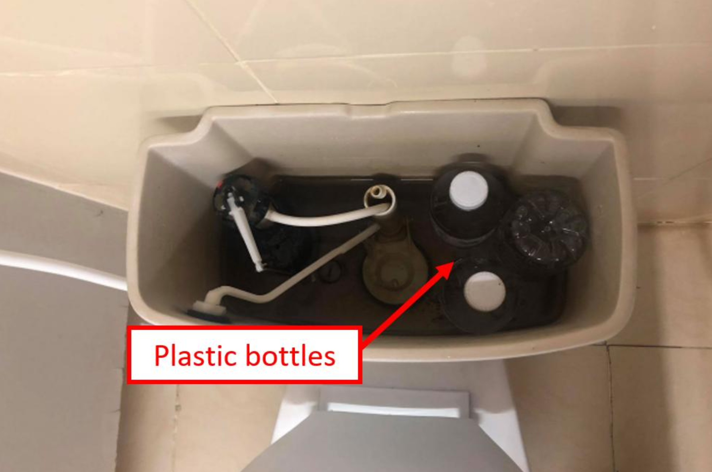 Plastic bottles placed inside a toilet water tank to reduce water usage