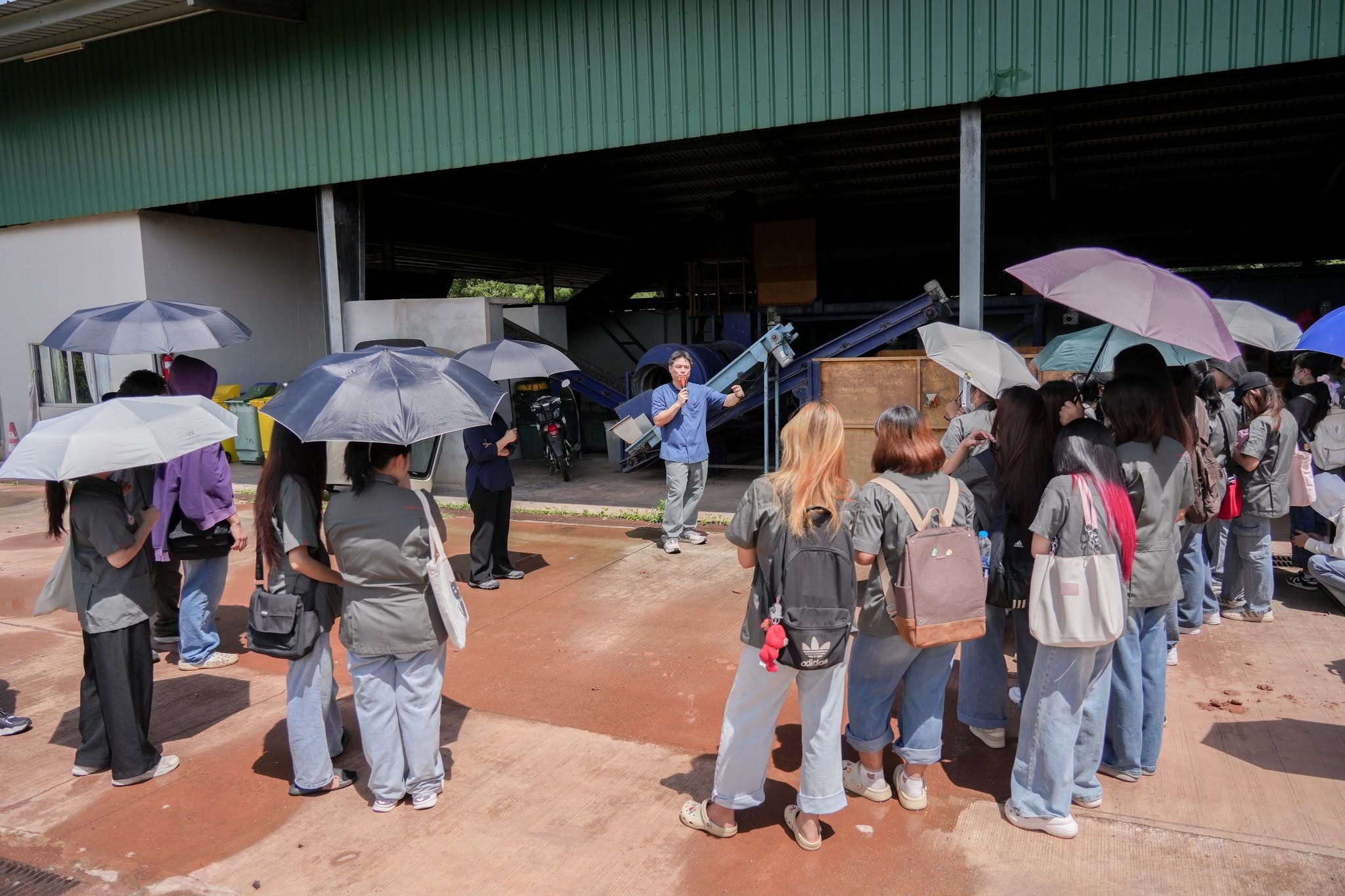 Students with umbrellas during a waste management course field visit