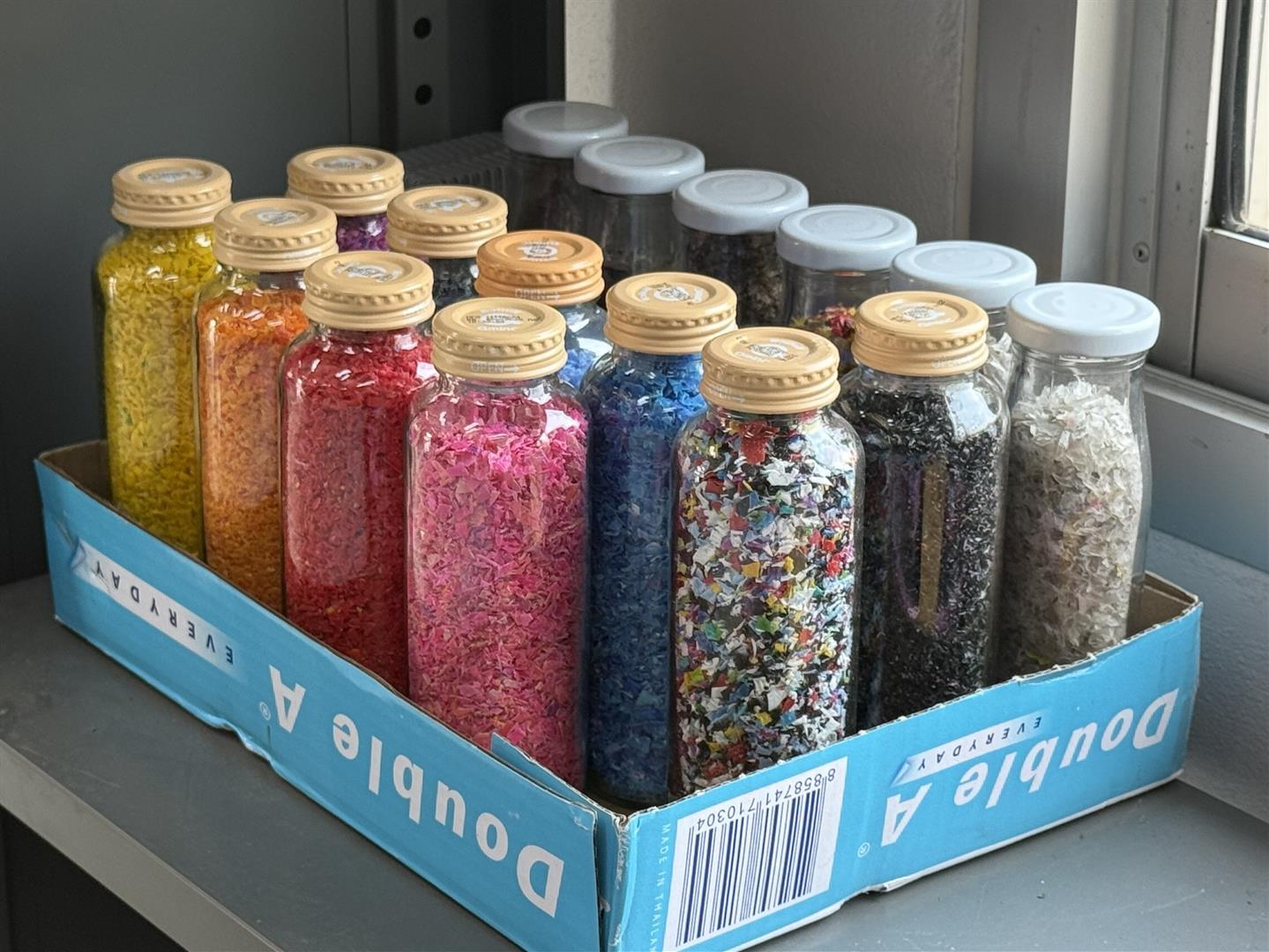 Sorted bottle caps by color and molds used to produce recycled plastic hangers